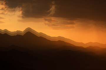 Obraz premium Mountains shape at sunset sky. Relaxing mountain landscape with colorful sunset, nature outdoor travel background.