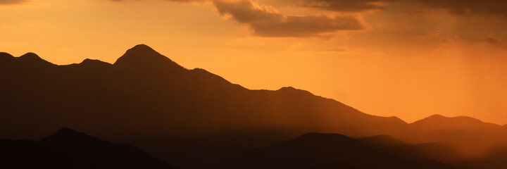 Obraz premium Mountains shape at sunset sky. Relaxing mountain landscape with colorful sunset, nature outdoor travel background.