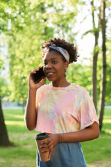 African young woman talking on mobile phone while standing outdoors
