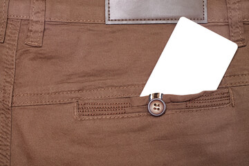 Close up of blank white card in back pocket of brown pants, copyspace.