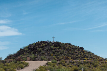 Fototapeta na wymiar Desert dirt road leading toward hill under a blue sky