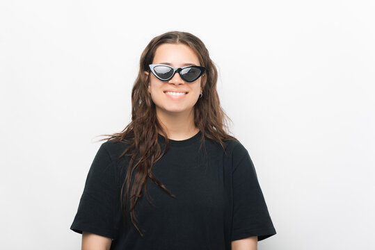 Portrait of smiling young trendy woman in black t-shirt and sunglasses