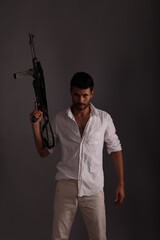 A man in white shirt with vintage submachine gun