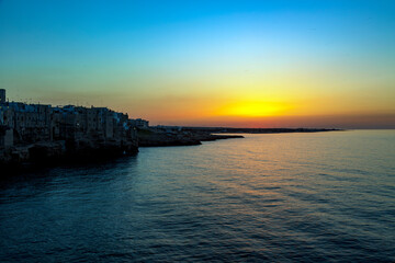 Obraz premium Sunset in Polignano a mare, in Bari in Puglia, a village by the sea