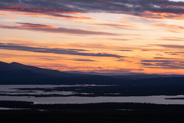 Wonderful sunset over the lake, forest and northern mountains of the Kola Peninsula