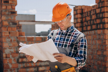 Young craftsman building a house
