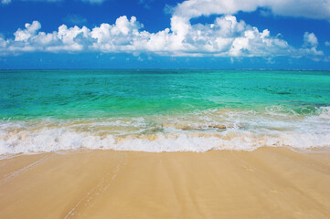Sand beach turquoise sea blue sky with white clouds