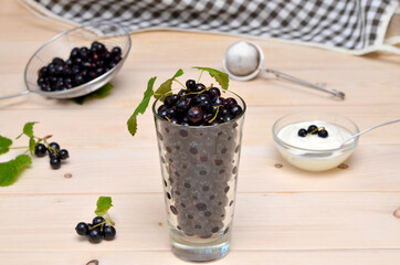 Fototapeta na wymiar still life with black currants in a glass on the kitchen table