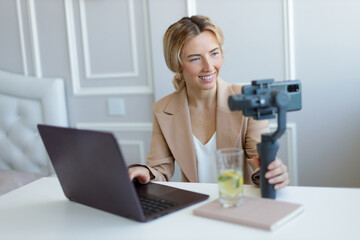Portrait of business woman in suit making video conference on mobile phone. Businesswoman talking looking at mobile phone on tripod.
