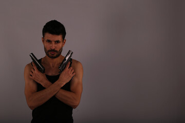 A man with two guns on gray background