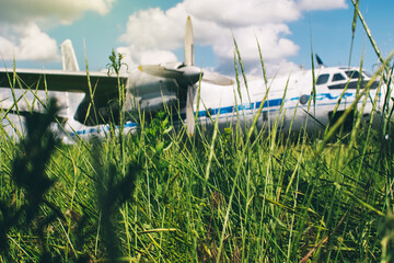 A close-up of an old wrecked passenger plane that has been decommissioned and stands for tourists. The fuselage shows traces of rust and chips. Parts of the metal structure are visible on the wings
