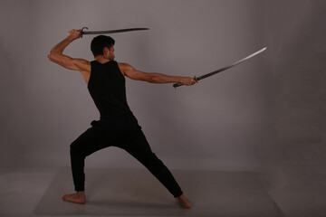 The fighter with two swords on gray background