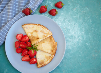 Pancakes, thin pancakes with fresh strawberries. On an empty background. Copy space.