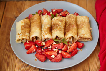 Pancakes, thin pancakes with fresh strawberries. On an empty background. Copy space.