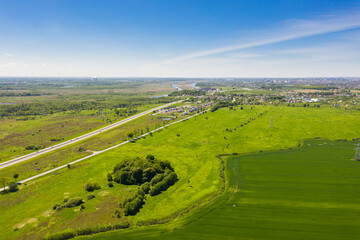 The agricultural fields near highway, view from a drone