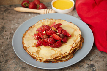 Pancakes, thin pancakes with fresh strawberries. On an empty background. Copy space.