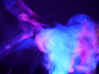 Abstract color series. Composition of colorful smoke in motion. Fusion of purple and blue mist isolated on a dark background to inspire creativity.