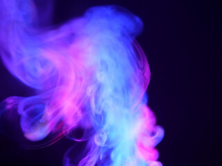 Abstract color series. Composition of colorful smoke in motion. Fusion of purple and blue mist isolated on a dark background to inspire creativity.