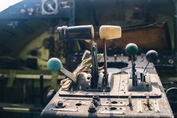 A close up of the cockpit of a vintage airplane. The steering wheel, dashboard, seat and climb levers are visible. Decommissioned aircraft. Everything is broken and damaged from time to time.
