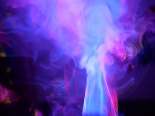 Abstract color series. Composition of colorful smoke in motion. Fusion of purple and blue mist isolated on a dark background to inspire creativity.