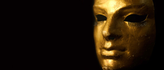 Carnival gold face mask with eyelashes on black background.