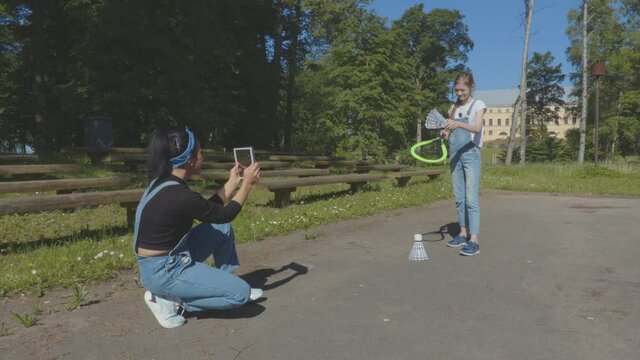 Mother take pictures of daughter with badminton set