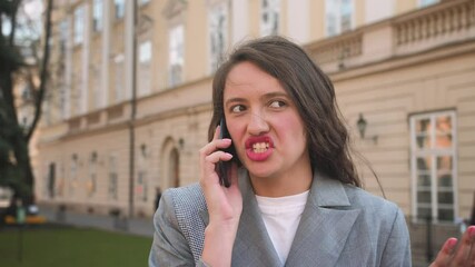 Portrait of aggressive businesswoman talking phone at street. Woman having phone talk outdoor