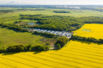 The farmland near rapeseed fields in the summertime, view from a drone