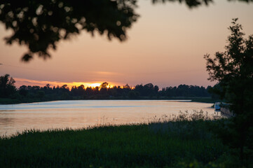 Fototapeta na wymiar Watching the sunset from the bank of the Lielupe in Jelgava / Saulriets pie Lielupes