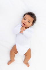 african-American small child on a white bed in the bedroom