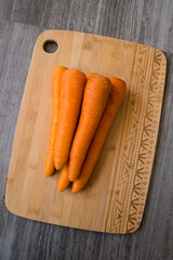 A pile of fresh carrots on the cutting board. 