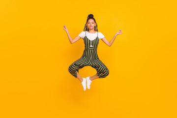 Full length photo of afro american young woman jump up asana yoga isolated on yellow color...