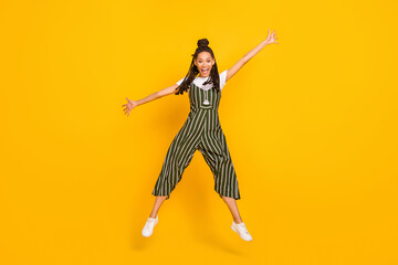 Full size photo of young african girl happy positive smile have fun jump up isolated over yellow color background