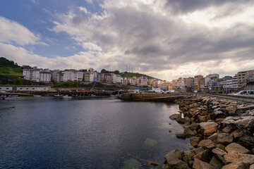 Beautiful sunset on the seaport next to the houses and filled of fishing boats in Malpica town Galicia Spain