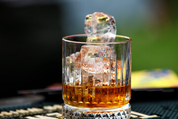 A glass of whiskey with ice.