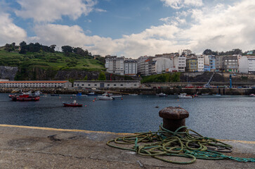 Malpica town seaport dock mooring cleat with boats ropes