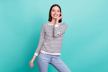 Fototapeta na wymiar Photo of adorable stunning sincere lady hand cheek look camera wear striped shirt isolated on teal background