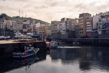 Fototapeta na wymiar Sunset of Beautiful seaport next to the houses and filled of fishing boats in Malpica Galicia Spain
