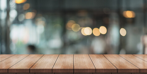 Empty wooden table top with lights bokeh on blur restaurant background.