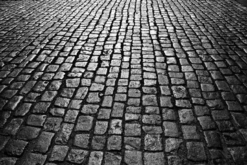 The road is made of black brick with reflected light.