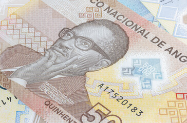 Close up to 500 Kwanza of the Republic of Angola. Polymer banknotes of the African country. Detailed capture of the portrait of the first president Agostinoh Neto. Currency bank note Kwanzas