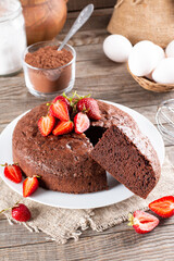 Piece of delicious fresh homemade chocolate sponge cake with strawberry on table