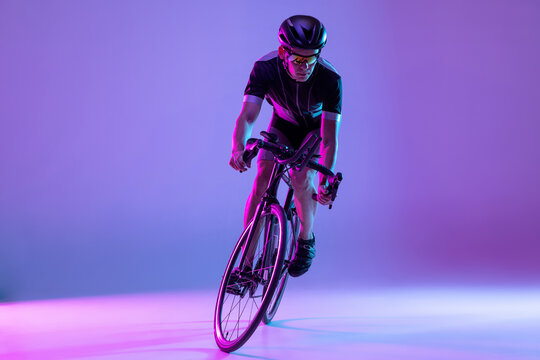 Cyclist riding a bicycle isolated against neon background