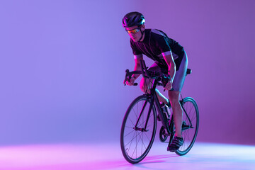 Cyclist riding a bicycle isolated against neon background