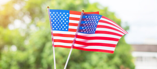 hand holding United States of America flag on green background. USA holiday of Veterans, Memorial, Independence ( Fourth of July) and Labor Day concept