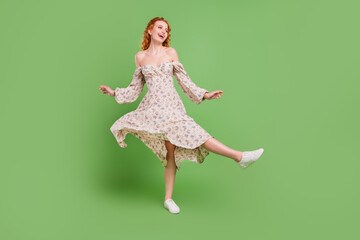 Full body photo of positive funky young woman good mood dance fly skirt isolated on green color background