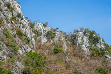 Rock mountain cliff and tree on the top. Beautiful Rock mountain and blue sky.