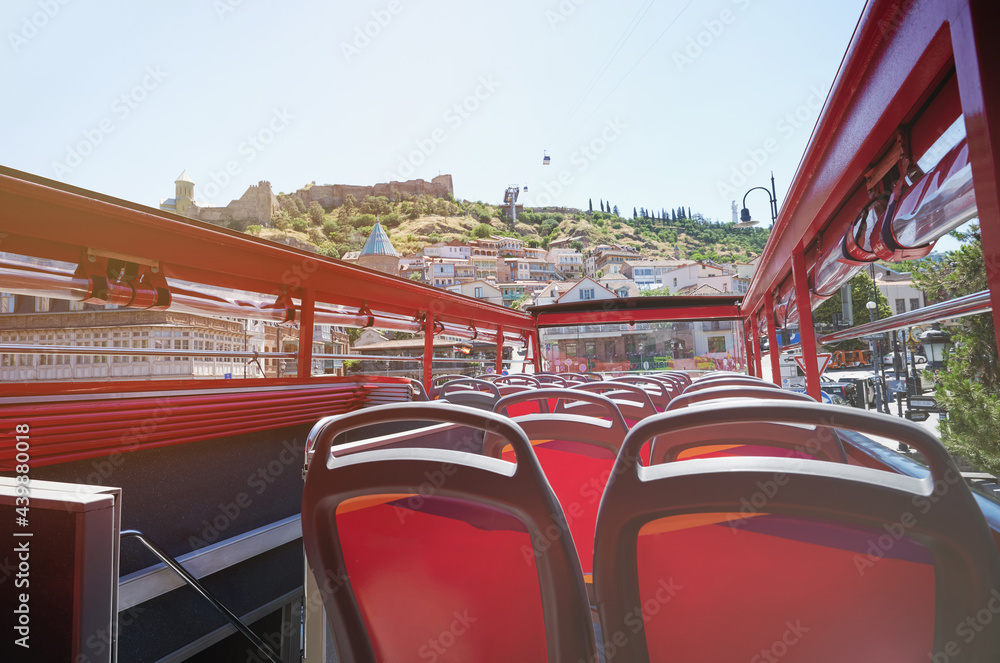 Wall mural back of red bus seats with open roof