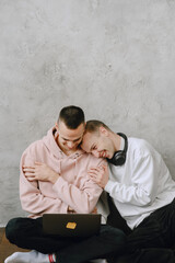 Gay couple consulting their travel plans together with a laptop