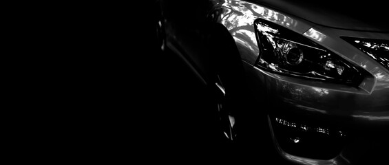 Black modern car closeup LED headlights on black background - Banner composition with copy space